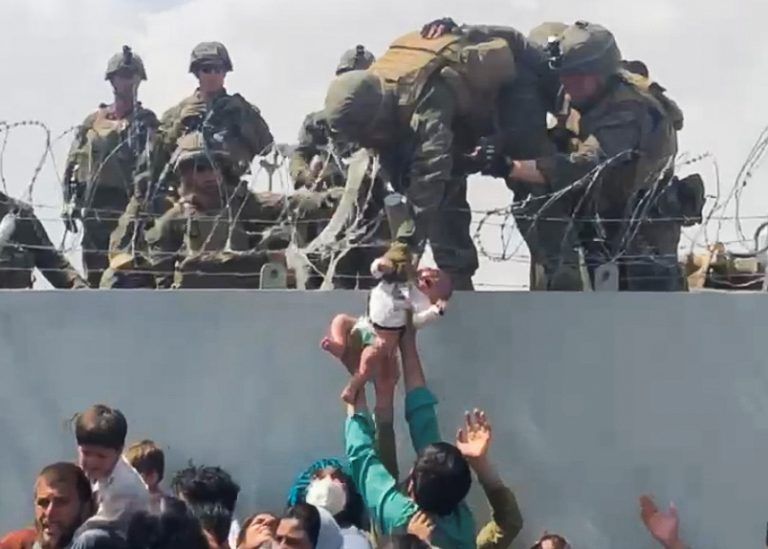 Panische Frauen reichen den amerikanischen Soldaten ihre Babys um diese zu retten. <span class="copyright">Reuters</span>