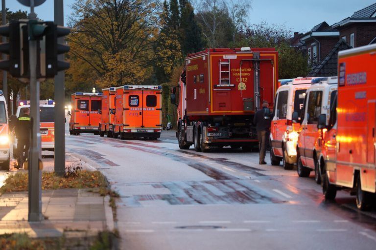 ABD0016_20231105 - HAMBURG - DEUTSCHLAND: 05.11.2023, Hamburg: Einsatzkräfte der Feuerwehr stehen auf der Alsterkrugchaussee während eines Einsatzes auf dem Hamburger Flughafen in Bereitschaft. Der Hamburger Flughafen ist nach dem Eindringen eines Fahrzeugs auf das Gelände gesperrt worden. Ein bewaffneter Mann hält auf dem Airport seine vierjährige Tochter in seiner Gewalt. Hintergrund soll nach Polizeiangaben ein Sorgerechtsstreit sein. Foto: Bodo Marks/dpa +++ dpa-Bildfunk +++. - FOTO: APA/dpa/Bodo Marks