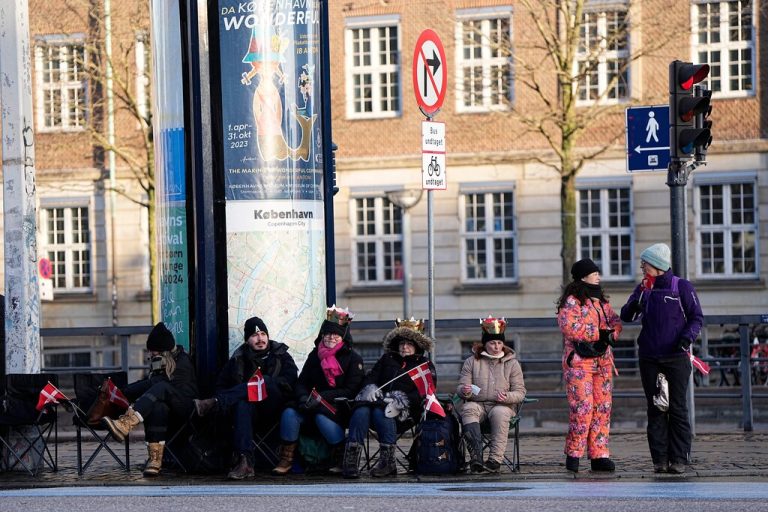 Members of the public sit in camping chairs on Christiansborg Palace Square ahead of the proclamation of abdication of Denmark's Queen Margrethe II, in Copenhagen on January 14, 2024. Denmark turns a page in its history on January 14 when Queen Margrethe abdicates and her son becomes King Frederik X, with more than 100,000 Danes expected to turn out for the unprecedented event. (Photo by Mads Claus Rasmussen / Ritzau Scanpix / AFP) / Denmark OUT