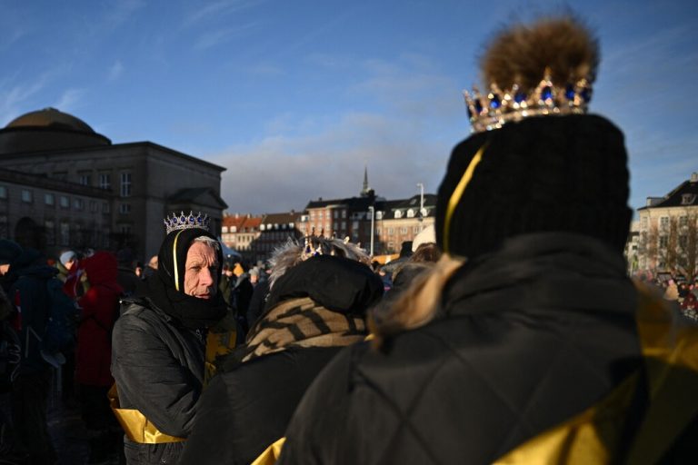 People wearing makeshift crowns and warm clothes at Christiansborg Palace Square wait for the start of the proclamation of abdication of Denmark's Queen Margrethe II, in Copenhagen, Denmark, on January 14, 2024. Denmark turns a page in its history on January 14 when Queen Margrethe abdicates and her son becomes King Frederik X, with more than 100,000 Danes expected to turn out for the unprecedented event. (Photo by Jonathan NACKSTRAND / AFP)