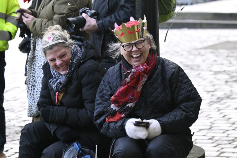 Susanne and Anette from Broendby wait for the royal procession at Christiansborg Slotsplads, in Copenhagen, Sunday, Jan. 14, 2024. Denmark's Crown Prince Frederik takes over the crown on Sunday from his mother, Queen Margrethe II, who is breaking with centuries of Danish royal tradition and retiring after a 52-year reign. (Nils Meilvang./Ritzau Scanpix via AP)