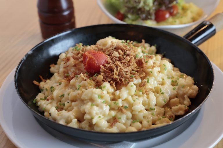 Kässpätzle mit Röstzwiebeln wird in einer kleinen Pfanne serviert. <span class="copyright">Hartinger</span>