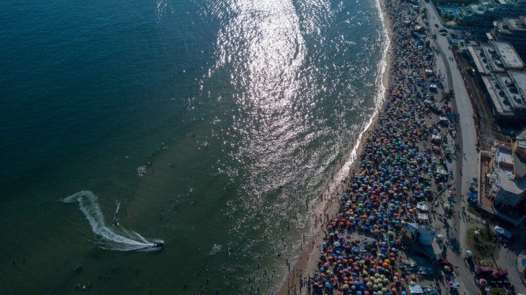 Aerial view of people enjoying Recreio dos Bandeirantes beach in Rio de Janeiro, Brazil, on March 17, 2024. (Photo by TERCIO TEIXEIRA / AFP)