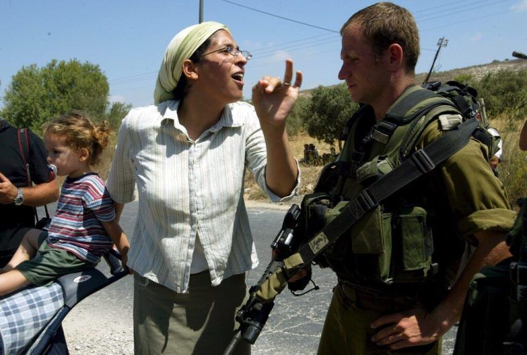 Eine jüdische Siedlerin konfrontiert einen israelischen Soldaten <span class="copyright">APA/ Alaa Badarneh</span>