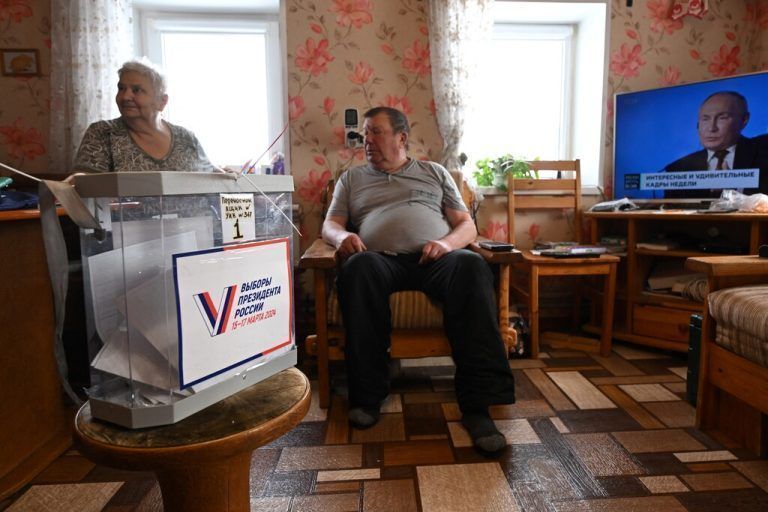 Local residents vote at their home during early voting for Russia's presidential election in the village of Yersenevo, Republic of Karelia, on March 10, 2024. (Photo by NATALIA KOLESNIKOVA / AFP)