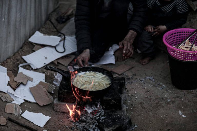 March 13, 2024, Deir Al Balah, Gaza Strip, Palestine: Gaza, Palestine. 13 March 2024. Displaced Palestinians cook very basic food outside their tents around the Shuhada al-Aqsa Hospital in Deir al-Balah, in the middle area of the Gaza Strip. The dire situation in Gaza continues unabated amid Israeli strikes and hardly any humanitarian aid being allowed into the war-ravaged Palestinian enclave. According to GazaÃââ s health ministry 27 people, most of them children, have died from malnutrition and dehydration, with the treat of famine constantly increasing Deir Al Balah Palestine - ZUMAd99_ 20240313_zap_d99_008 Copyright: xAdelxAlxHwajrex