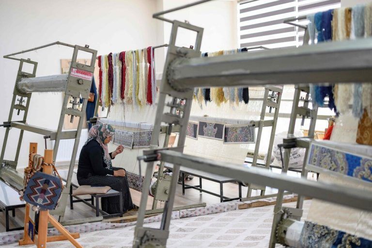 A woman knits a carpet at the Karakopru Carpet Production Centre in Sanliurfa, southeastern Turkey, on October 18, 2023. With the European Union's help, Turkey is quietly setting up integration-through-work programmes -- even if few officials publicly admit that the Syrians are probable here to stay. The sides signed a landmark deal in 2016 aimed at relieving Europe's migrant crisis. Brussels has released nearly 10 billion euros since 2011 for schools, healthcare, and training programmes. (Photo by Yasin AKGUL / AFP)