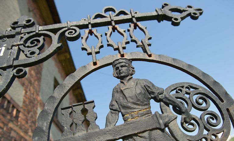 ARCHIV - 19.05.2014, Mecklenburg-Vorpommern, Greifswald: Ein schmiedeeisernes Zunftzeichen - ein Mann mit einem Schlüssel - hängt an der Fassade einer Kunstschlosserei. (zu dpa: «Handwerk in MV pessimistisch - Nur Autowerkstätten geht es besser») Foto: Stefan Sauer/dpa +++ dpa-Bildfunk +++