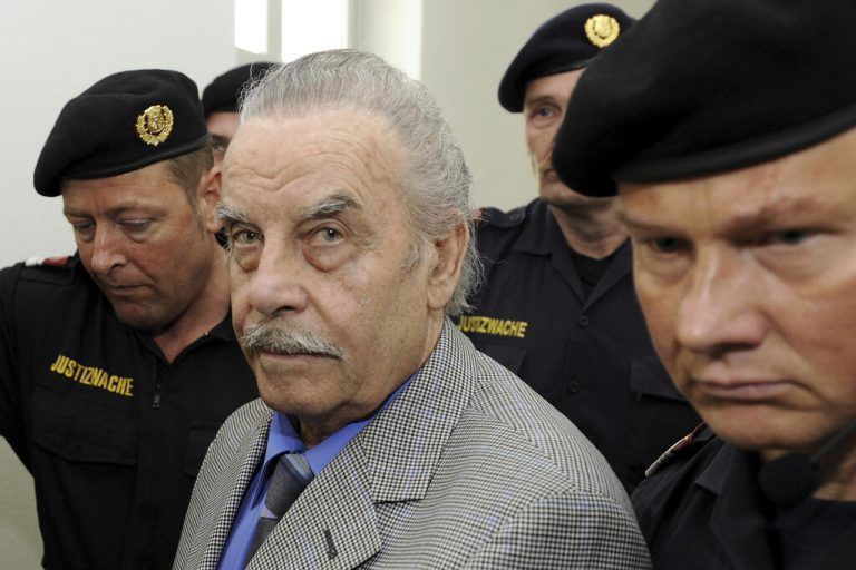 FILE - Defendant Josef Fritzl, center, is escorted to the fourth day of his trial in the provincial courthouse in St. Poelten, Austria, Thursday, March 19, 2009. Fritzl, who kept his daughter captive for 24 years, raped her thousands of times, and father seven of her children, can be moved from psychiatric detention to a normal prison under certain conditions, a court ruled Thursday, Jan. 25, 2024. Josef Fritzl, who is 88, will have to attend regular psychotherapy and undergo psychiatric evaluations during a 10-year probation period, Austria Press Agency reported. (Robert Jaeger/Pool Photo via AP, file)