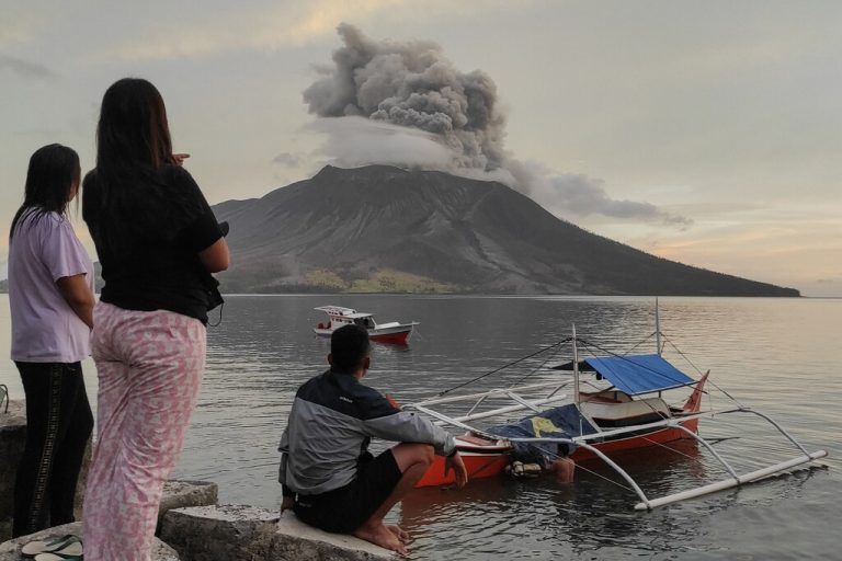 People look at the eruption of Mount Ruang volcano on Tagulandang Island in Sitaro, North Sulawesi, on April 19, 2024. (Photo by Ronny Adolof BUOL / AFP)