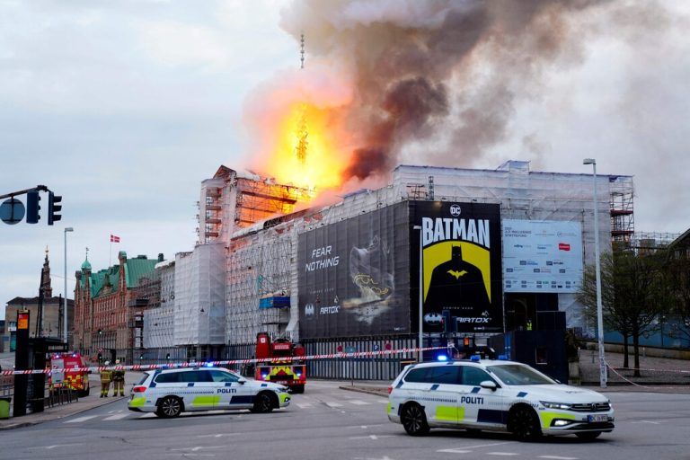 Police cars park as flames engulf the Copenhagen's Stock Exchange building, in Copenhagen, on April 16, 2024. (Photo by Ida Marie Odgaard / Ritzau Scanpix / AFP) / Denmark OUT