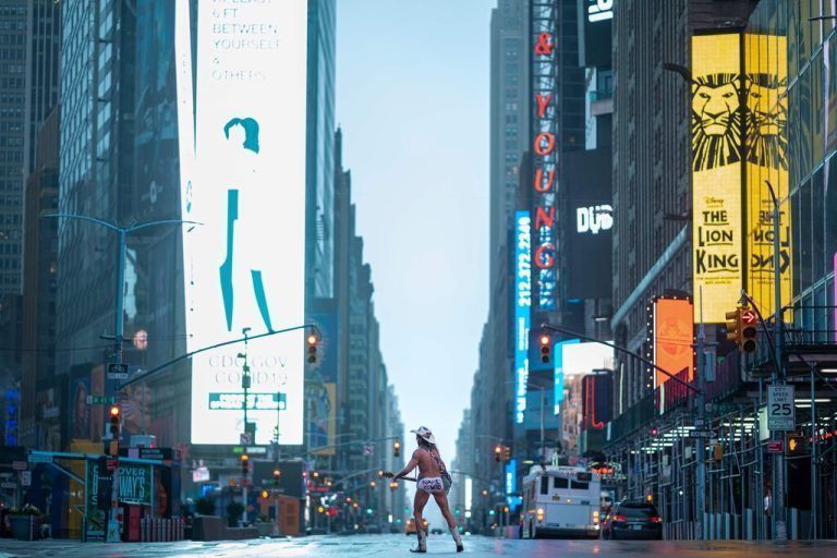 TOPSHOT - Street performer Robert John Burck, known as The Naked Cowboy, plays guitar amid coronavirus concern in the almost deserted Times Square on April 13, 2020 in New York City. - New York's governor declared April 13, 2020 that the 'worst is over' for its coronavirus outbreak providing the state moves sensibly, despite reporting its death toll had passed 10,000. Andrew Cuomo said lower average hospitalization rates and intubations suggested a 'plateauing' of the epidemic and that he was working on a plan to gradually reopen the economy. (Photo by Johannes EISELE / AFP)