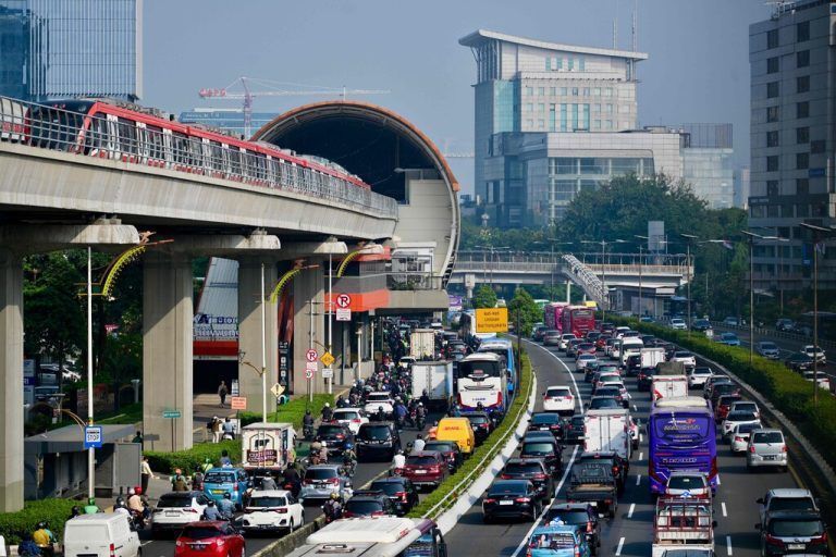 A light rapid transit (LRT) and motorists commute during the morning rush hour in Jakarta on June 4, 2024. (Photo by BAY ISMOYO / AFP)