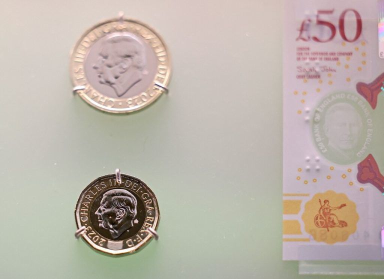 Bank notes and coins that feature an image of Britain's King Charles III are pictured on display during a photocall for 'The Future of Money' exhibition, at the Bank of England Museum in the City of London on February 27, 2024. The currency is set to enter circulation in June 2024, with the exhibition set to run from February 28 until September 2025. (Photo by Daniel LEAL / AFP)