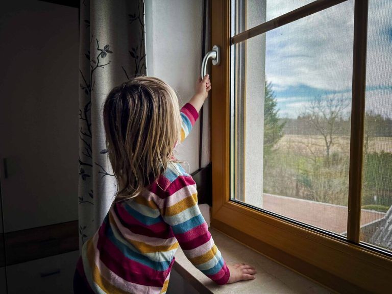 01.03.2024, Ranshofen, AUT, Unterwegs in Oberösterreich, Themenbild, Verschiedene Themenbilder, Symbolbild, Kleinkind, Fenster, Sturz, im Bild Kind, Kleinkind versucht ein Fenster zu Öffnen, Fotografiert von Hinten, Unfall, Fenster, Kleinkind, Sturz aus dem Fenster, *** 01 03 2024, Ranshofen, AUT, On the road in Upper Austria, Theme picture, Various theme pictures, Symbolic picture, Toddler, Window, Fall, in the picture child, Toddler tries to open a window, Photographed from behind, Accident, Window, Toddler, Fall from the window,