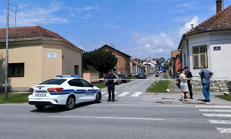 A police officer stands guard behind a police tape next to a retirement home (L) where at least five people were killed in a shooting in Daruvar, some 130km from Zagreb on July 22, 2024. At least five people were killed on July 22, 2024, in a retirement home in eastern Croatia, national television reported. According to initial reports in the local media, the suspect, a veteran born in 1973, entered the home and opened fire, reportedly killing his mother and four other residents and employees. He managed to escape, but was quickly arrested by the police in a nearby cafe, who declined to comment for the moment. (Photo by Nikola Blazekovic / AFP)
