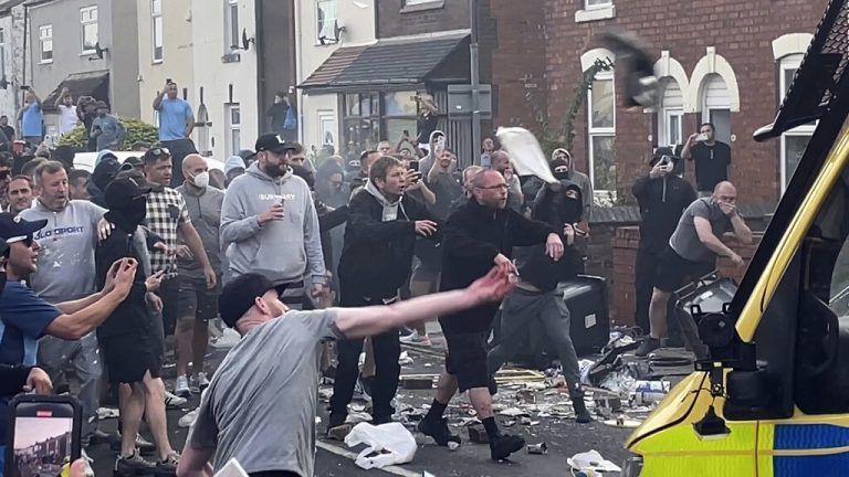 An unruly crowd clash with police, Tuesday, July 30, 2024, in Southport, northwest England, near where three girls were stabbed to death in a dance class the day before. The violence erupted shortly after a peaceful vigil was attended by hundreds in the center of Southport to mourn the 13 victims of the stabbings, including seven still in critical condition. (Richard McCarthy/PA via AP)