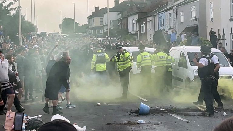 An unruly crowd clash with police, Tuesday, July 30, 2024, in Southport, northwest England, near where three girls were stabbed to death in a dance class the day before. The violence erupted shortly after a peaceful vigil was attended by hundreds in the center of Southport to mourn the 13 victims of the stabbings, including seven still in critical condition. (Richard McCarthy/PA via AP)