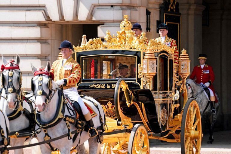 Britain's King Charles III salutes as he travels with Britain's Queen Camilla (unseen), in Diamond Jubilee State Coach as they leave from Buckingham Palace in London on July 17, 2024, headed for the Houses of Parliament, for the State Opening of Parliament ceremony. (Photo by Andrew Matthews / POOL / AFP)