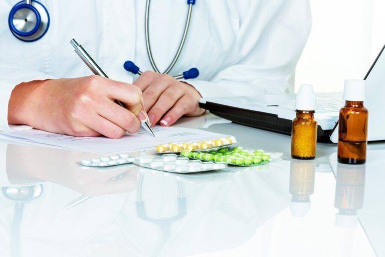 Eine junge Ärztin verschreibt Medikamente. Rezeptpflichtige Tabletten werden vom Arzt verordnet.
