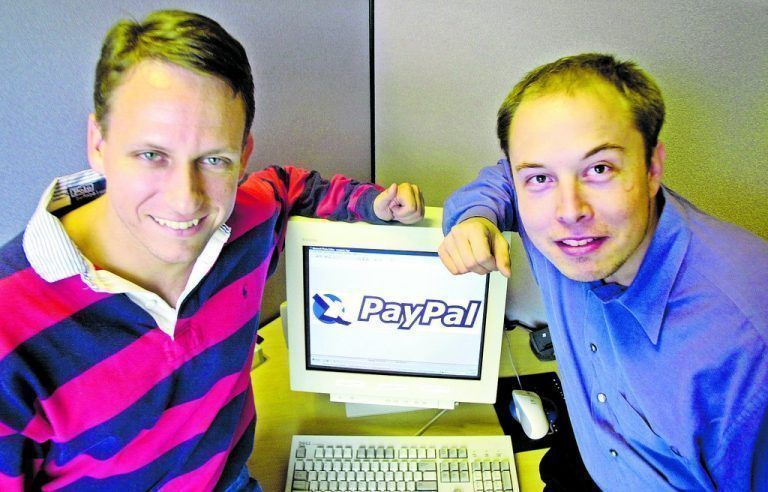 FILE - In this Oct. 20, 2000 file photo, PayPal Chief Executive Officer Peter Thiel, left, and founder Elon Musk, right, pose with the PayPal logo at corporate headquarters in Palo Alto, Calif. Thiel who who co-founded PayPal and gave Facebook its first big investment now wants Silicon Valley to buy into a bigger idea: the future. Thiel is backing groups that see a future when computers will communicate directly with the human brain. Seafaring pioneers will found new floating nations in the middle of the ocean. Science will conquer aging, and death will become a curable disease. (AP Photo/Paul Sakuma, File)