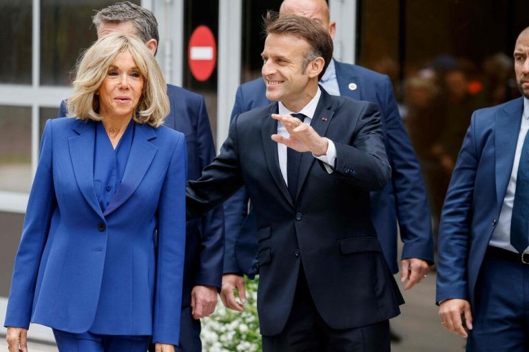 France's President Emmanuel Macron (C), flanked by French President's wife Brigitte Macron (L), waves upon his arrival to vote in the second round of France's legislative election at a polling station in Le Touquet, northern France on July 7, 2024. (Photo by Ludovic MARIN / AFP)