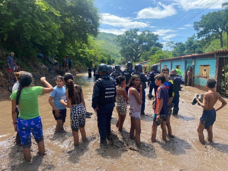 Residents and members of the Bolivarian National Police stand on a flooded street after a river swelled due to heavy rains following the passage of Hurricane Beryl on the road from Cumana to Cumanacoa, Sucre State, Venezuela, on July 2, 2024. Hurricane Beryl churned towards Jamaica Tuesday after killing at least five people and causing widespread destruction across the southeastern Caribbean, threatening deadly winds and storm surge as it approached. (Photo by Victor GONZALEZ / AFP)