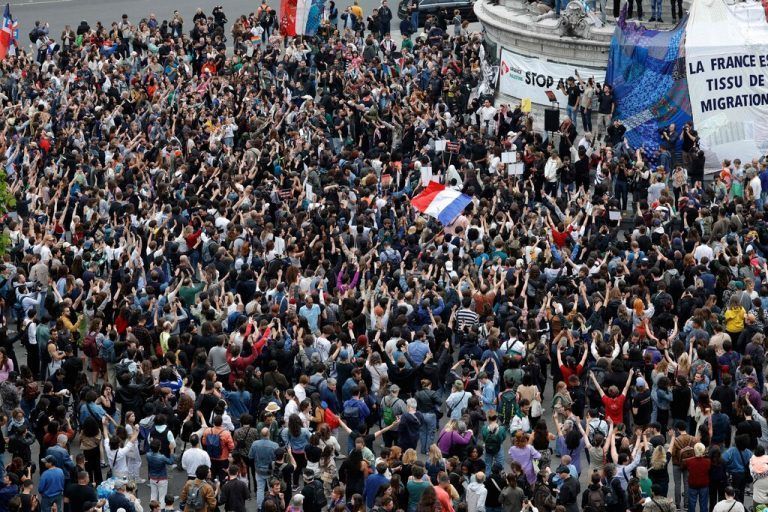 TOPSHOT - People wave national flags during an election night event following the first results of the second round of France's legislative election at Republique Square in Paris on July 7, 2024. A broad left-wing coalition was leading a tight French legislative election, ahead of both President's centrists and the far right with no group winning an absolute majority, projections showed. (Photo by Geoffroy VAN DER HASSELT / AFP)