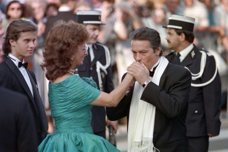(FILES) French actor Alain Delon kisses Italian actress Sophia Loren's hand during the Opening Ceremony at the 42th edition of the Cannes Film Festival in Cannes, southern France on May 11, 1989. French film legend Alain Delon has died at the age of 88, his three children told AFP in a statement on August 18, 2024, following a battle with ill health. (Photo by AFP)