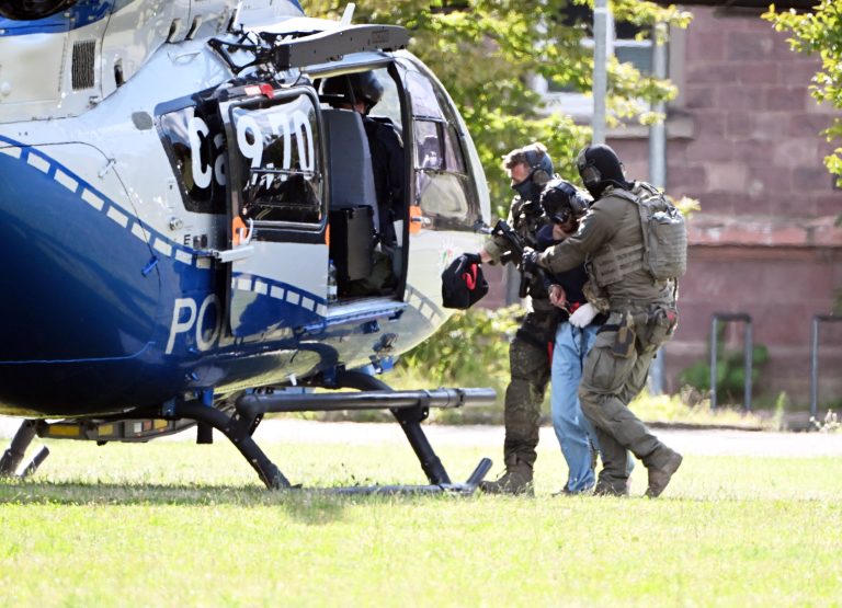 ABD0029_20240825 – KARLSRUHE – DEUTSCHLAND: 25.08.2024, Baden-Wrttemberg, Karlsruhe: Der mutmassliche Tter des Messerangriffs von Solingen wird zu einem Hubschrauber gebracht. Zuvor war der Verdchtige dem Ermittlungsrichter beim Bundesgerichtshof (BGH) vorgefhrt worden, der Haftbefehl erlassen hat. Foto: Uli Deck/dpa +++ dpa-Bildfunk +++. – FOTO: APA/dpa/Uli Deck
