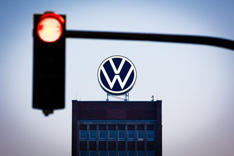 ABD0013_20240904 - WOLFSBURG - DEUTSCHLAND: 04.09.2024, Niedersachsen, Wolfsburg: Das VW-Logo leuchtet auf dem Dach des Markenhochhauses im Volkswagen Stammwerk am frühen Morgen hinter einer rot zeigenden Ampel. Volkswagen hat angekündigt, wegen der angespannten Lage der Kernmarke den Sparkurs zu verschärfen. Auch betriebsbedingte Kündigungen und Werksschließungen könnten nicht länger ausgeschlossen werden. Foto: Moritz Frankenberg/dpa +++ dpa-Bildfunk +++. - FOTO: APA/dpa/Moritz Frankenberg