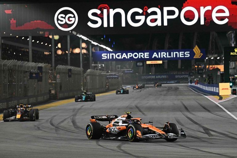 McLaren's British driver Lando Norris (C) drives during the Formula One Singapore Grand Prix night race at the Marina Bay Street Circuit in Singapore on September 22, 2024. (Photo by Lillian SUWANRUMPHA / AFP)