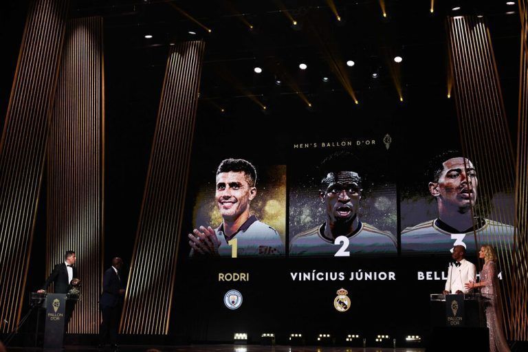 Manchester City's Spanish midfielder Rodri (L) receives the Ballon d'Or award from former President of Liberia and former Liberian football player George Weah (2L) as he wins in front of second-placed Real Madrid's Brazilian forward Vinicius Junior and third-placed Real Madrid's English midfielder Jude Bellingham during the 2024 Ballon d'Or France Football award ceremony at the Theatre du Chatelet in Paris on October 28, 2024. (Photo by Franck FIFE / AFP)