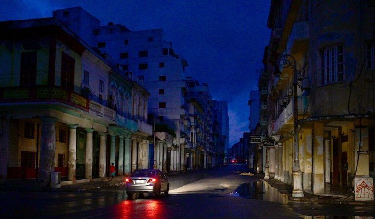 TOPSHOT - A car drives along a street during a nationwide blackout caused by a grid failure in Havana, on October 19, 2024. Technical breakdowns, fuel shortages and high demand have caused the country's thermoelectric power plants to constantly fail, forcing the government to declare an energy emergency and take measures such as closing schools and factories. (Photo by ADALBERTO ROQUE / AFP)