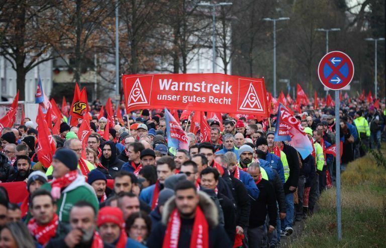 Employees of German car maker Volkswagen (VW) demonstrate outside the VW commercial cars plant on December 2, 2024 in Hanover, northern Germany, as thousands of Volkswagen workers go on strike all over Germany in an escalating industrial dispute at the crisis-hit German auto giant with thousands of jobs at stake. VW has been hit hard by high manufacturing costs at home, a stuttering shift to electric vehicles and tough competition in key market China. It has announced a plan to cut billions of dollars in costs. (Photo by Ronny HARTMANN / AFP)