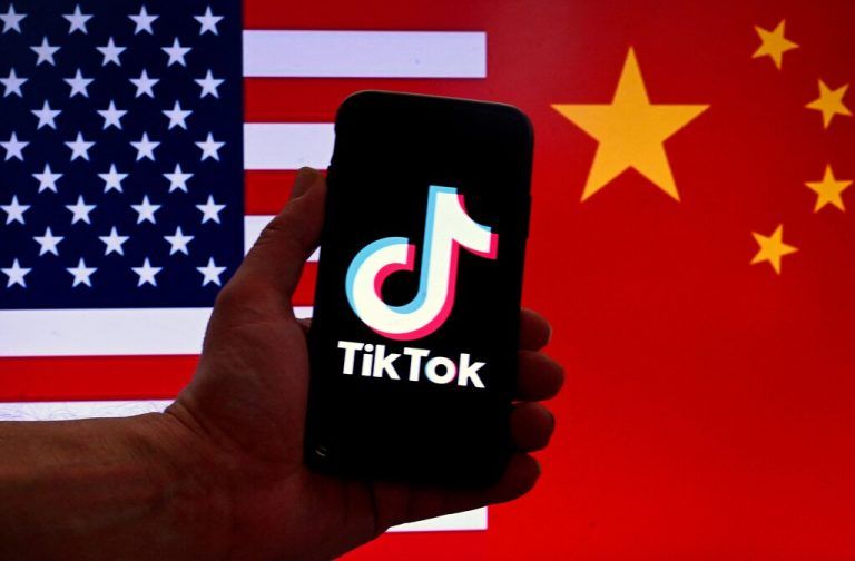 (FILES) In this photo illustration the social media application logo for TikTok is displayed on the screen of an iPhone in front of a US flag and Chinese flag background in Washington, DC, on March 16, 2023. TikTok faces a US ban after an appeals court on December 6, 2024, rejected its challenge to a law requiring the video-sharing app to divest from its Chinese parent company by January 19. The potential ban could strain US-China relations just as president-elect Donald Trump prepares to take office on January 20. (Photo by OLIVIER DOULIERY / AFP)